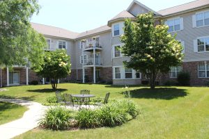 Sauk Gardens apartment complex backyard with outdoor table and four chairs on a sunny summer day