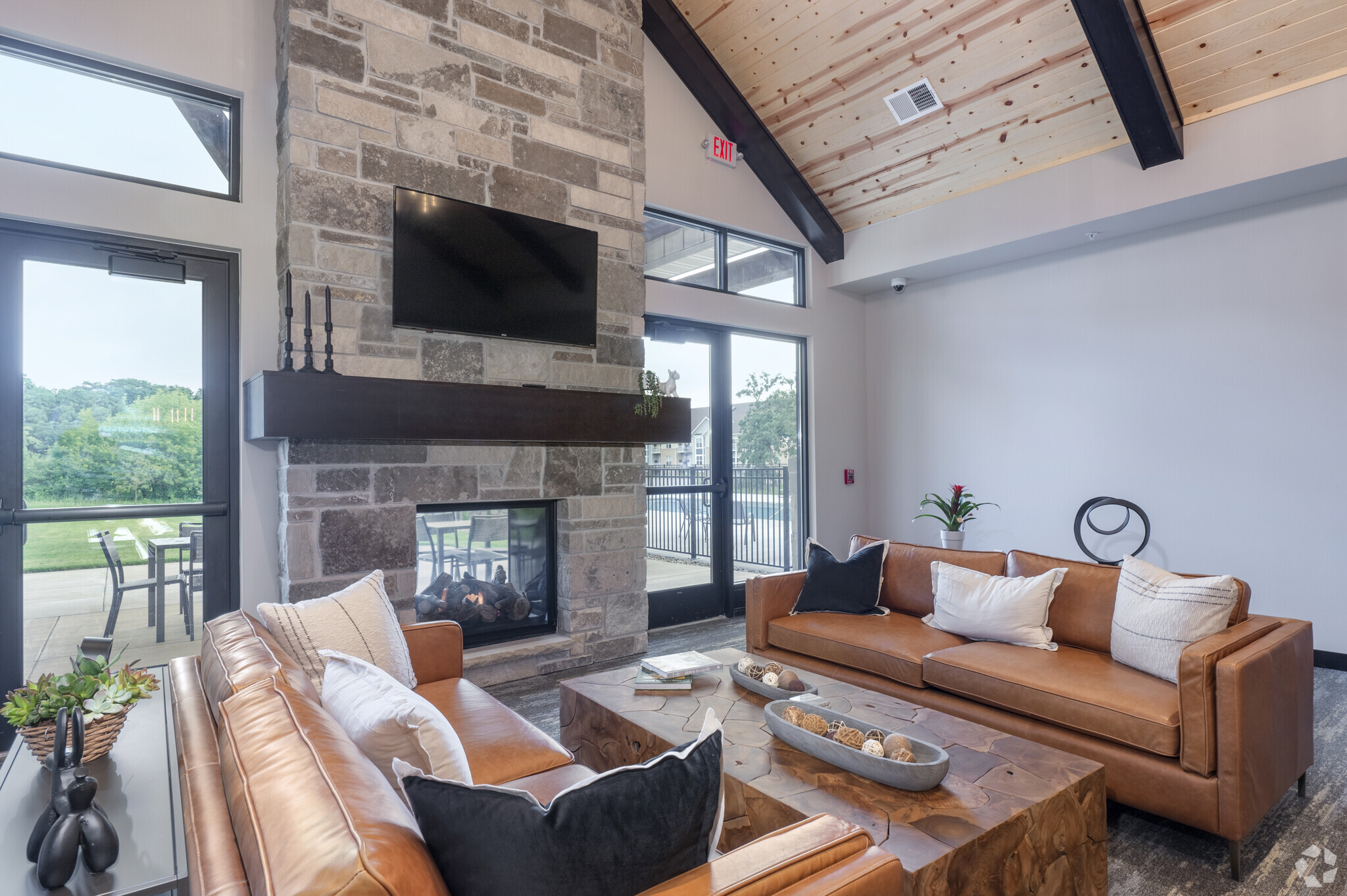 the clubhouse of Irish Fields apartments with lounge ceiling and a TV over a mantle